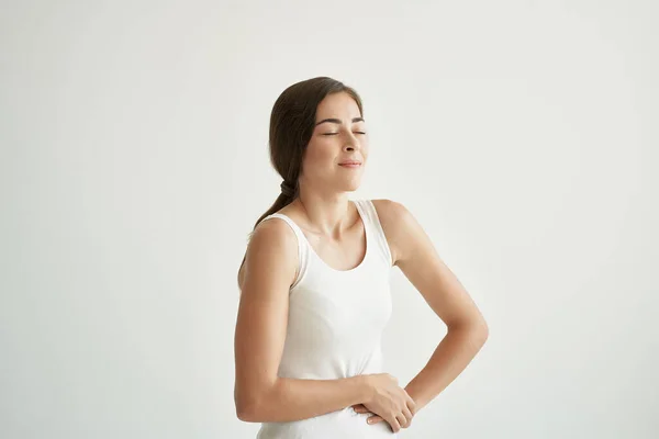 Γυναίκα σε λευκό t-shirt κρατώντας την κοιλιά της διάρροια πρόβλημα υγείας — Φωτογραφία Αρχείου