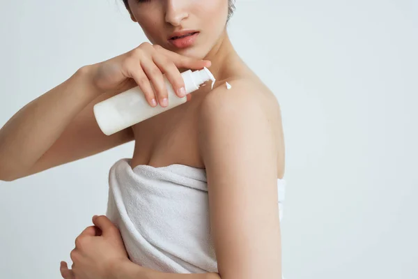 Mulher com ombros nus aplicando loção na pele hidratante close-up — Fotografia de Stock