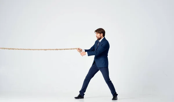 Business man in a suit with a rope in his hands manager office light background — Stock Photo, Image