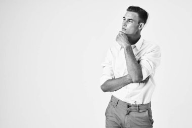 Beyaz gömlekli, saç stili, kendine güvenen, hafif arka planlı bir adam.