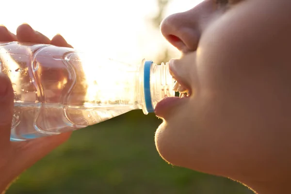 Vidám nő ivóvíz egy üveg nyári közelkép — Stock Fotó