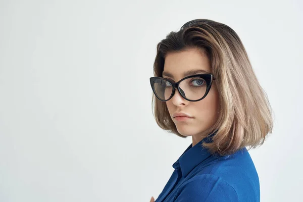 Elegante vrouw draagt bril blauw shirt studio — Stockfoto