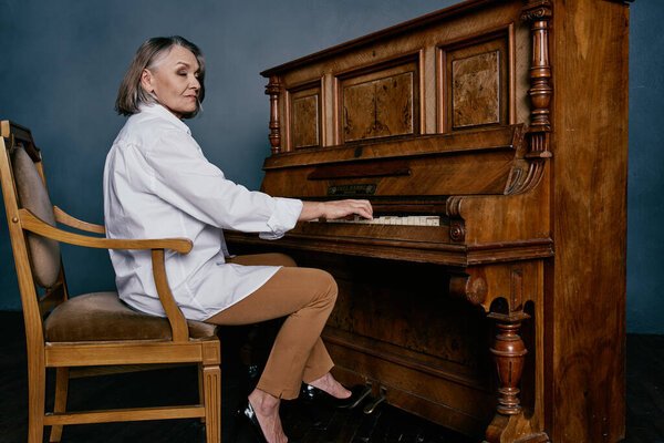 woman music teacher sitting near the piano