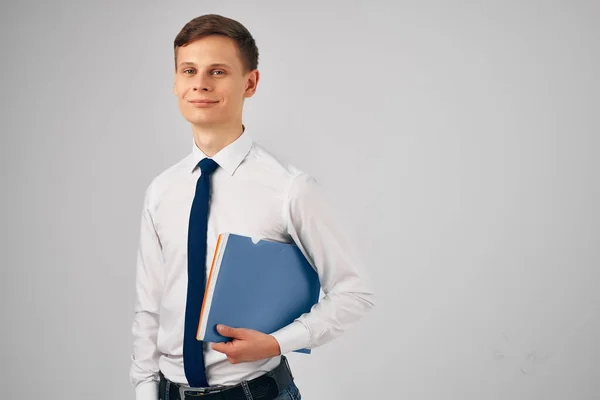 Mann im Hemd mit Krawatte blauer Ordner in den Händen grauer Hintergrund — Stockfoto