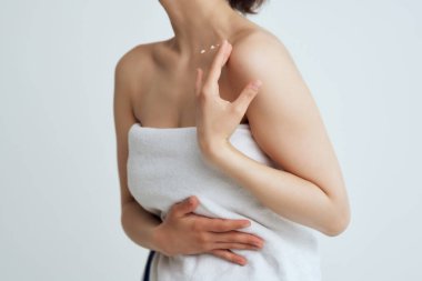 Çıplak omuzlu, temiz ciltli bir kadın.