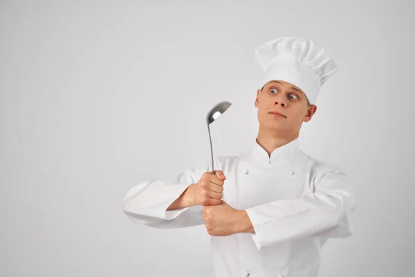 Ein Mann in Kochuniform versorgt ein Restaurant mit Küchenutensilien — Stockfoto