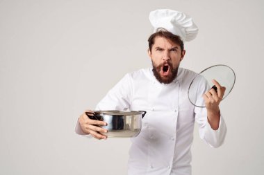 Üniformalı bir adam elinde tavayla restoran endüstrisini pişiriyor.