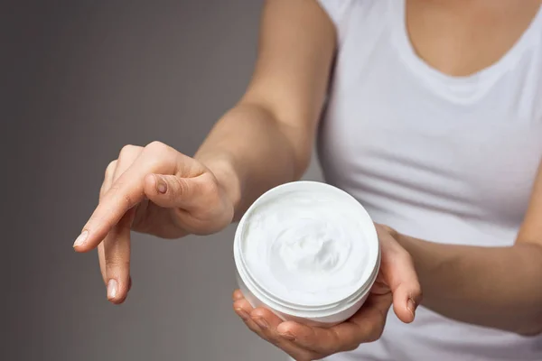 Mulher em t-shirt branca mantém creme nas mãos cuidados com a pele hidratante higiene da saúde — Fotografia de Stock