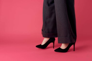 Kadın ayakları siyah ayakkabılar kırpılmış pembe arka plan modern tarz cazibe