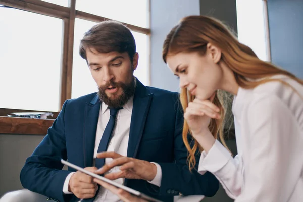 Uomo e donna in giacca e cravatta guardando i professionisti tablet manager — Foto Stock