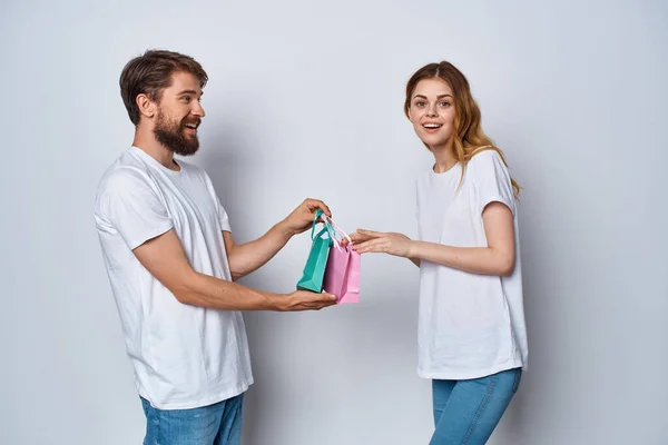 Joven pareja en blanco camisetas regalos diversión emociones vacaciones —  Fotos de Stock