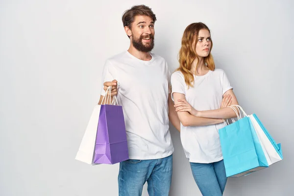 Joven pareja en blanco camisetas compras divertido —  Fotos de Stock