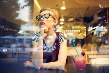 Kafe kokteylinde güzel bir kadın oturuyor.