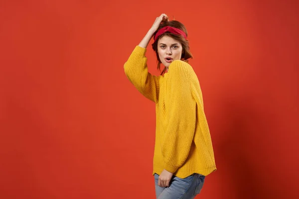머리에 노란 스웨터를 입고 손으로 포즈를 취하는 예쁜 여성 — 스톡 사진