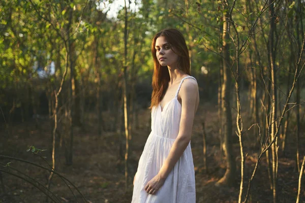 Mulher bonita em branco vestido caminha na floresta natureza resto — Fotografia de Stock