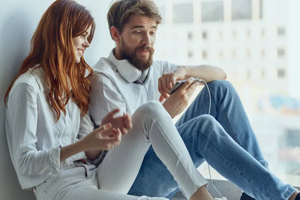 Una joven pareja charlando cerca de la ventana romance alegría tecnología — Foto de Stock