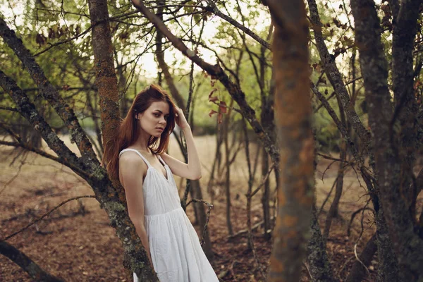 Yaz tatili için ağaçların yanında beyaz elbiseli bir kadın. — Stok fotoğraf