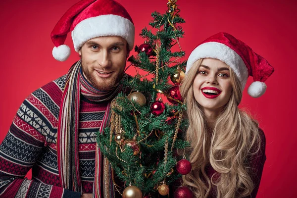 Homem e mulher em roupas de Ano Novo divertido árvore de Natal decoração retrato — Fotografia de Stock