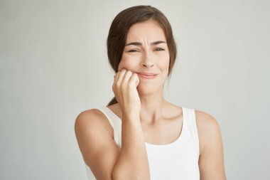 Beyaz tişörtlü kadın ve diş ağrısı çeken diş hekimi.