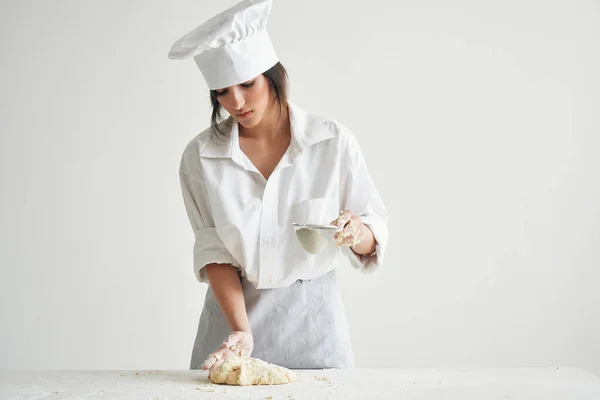 woman baker in working rolls out dough. High quality photo