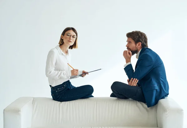 Uomo e donna comunicazione divano bianco emozioni team documenti — Foto Stock