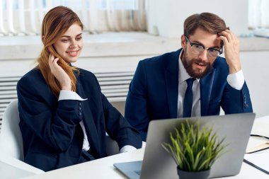 Laptop ofis teknolojisinin önünde masada oturan meslektaşlarım.