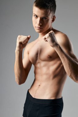 Gri arka planda boksör. Gövde küpleri mide geliştirici fitness üzerinde.