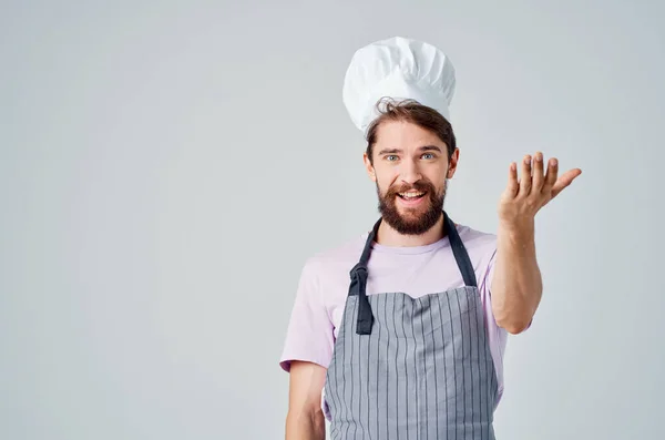 Um homem em um chefs emoções uniformes de um trabalho profissional na cozinha — Fotografia de Stock