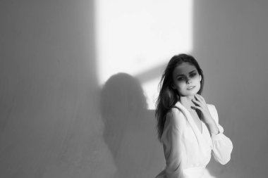 Stüdyoda poz veren lüks giyinmiş bir kadın.