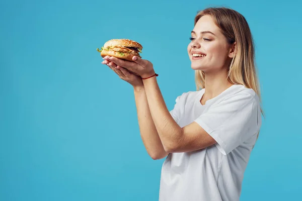 Vrouw met hamburger fast food levering snack leuk blauw achtergrond — Stockfoto