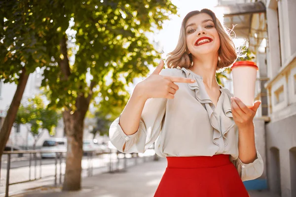 Веселая женщина с чашкой кофе на открытом воздухе летом — стоковое фото