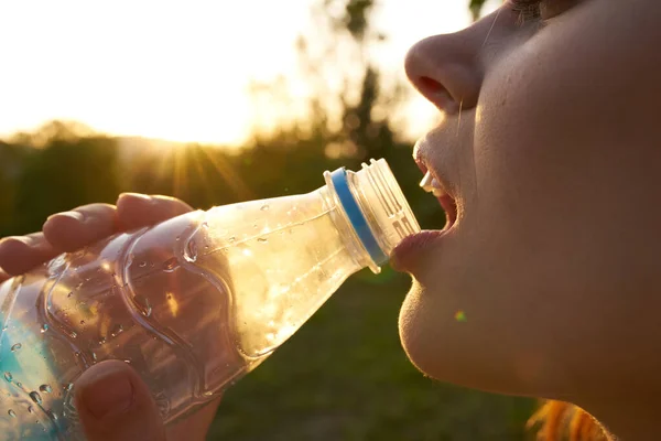 Vacker kvinna dricksvatten från en flaska ansikte närbild — Stockfoto