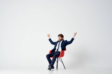 Takım elbiseli bir iş adamı bir ofis müdürünün üzerinde oturuyor.