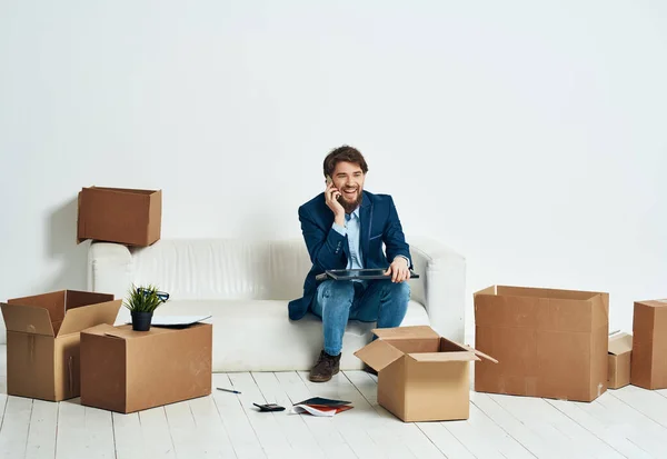 Manager sitzt auf einer weißen Couch Boxen mit Dingen, die sich professionell bewegen — Stockfoto