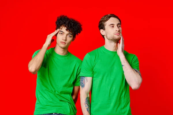 Due uomini in t-shirt verdi stanno fianco a fianco comunicazione emozioni amicizia — Foto Stock