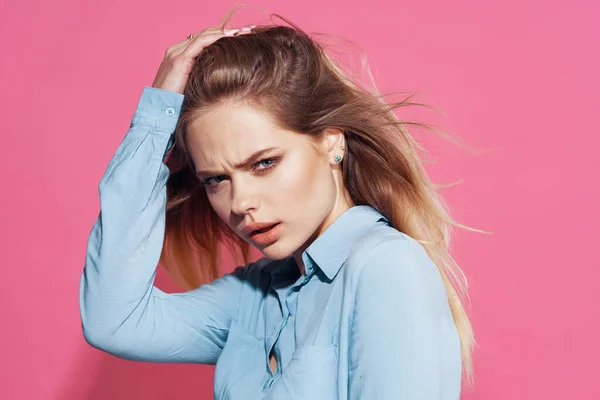 Mooi blond in blauw shirt cosmetica roze achtergrond — Stockfoto