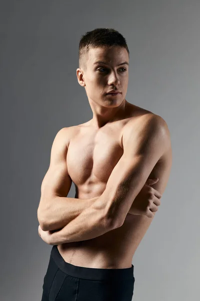 Sexy bodybuilder incrociato braccia sul petto su sfondo grigio ritagliato vista da vicino — Foto Stock