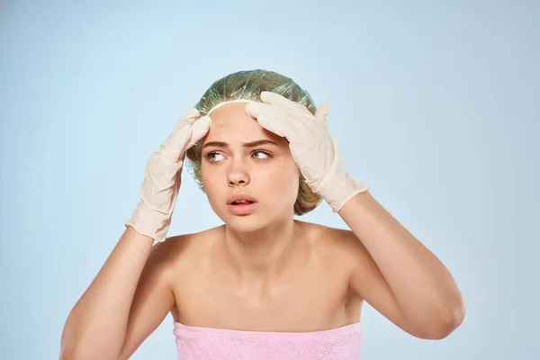 Vrouw met blote schouders knijpt uit handschoen puistjes douche cap — Stockfoto