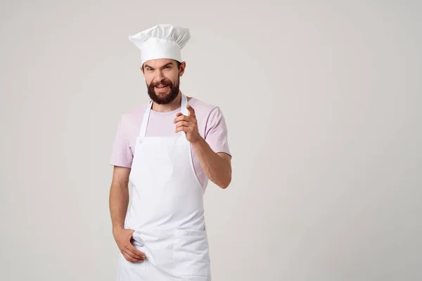 Homem em roupas de chefs cozinhar alimentos cozinha profissão luz fundo — Fotografia de Stock