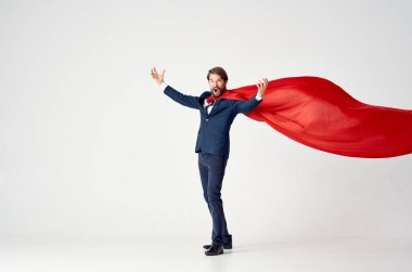 Süper kahraman kıyafeti giymiş kırmızı pelerinli bir adam güç koruması.