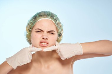 Çıplak omuzlu bir kadın, yüz dermatolojisine sivilceler sıkıyor.