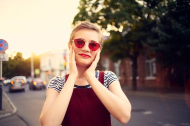 Kısa saçlı kadın güneş gözlüğü takıyor açık havada romantizm yaşıyor.