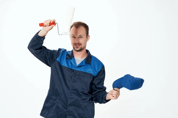 Egy munkaruhás férfi, egy görgő, aki falakat fest a kezébe, dekoráció javítás — Stock Fotó