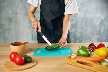 Siyah önlüklü kadın, vejetaryen yemek kesme tahtasında öğle yemeği yiyor.