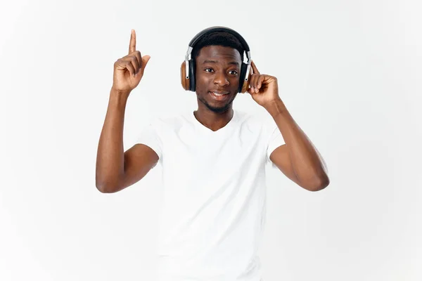 Mann mit afrikanischem Aussehen in Kopfhörer Musik hören weißes T-Shirt isoliert Hintergrund — Stockfoto