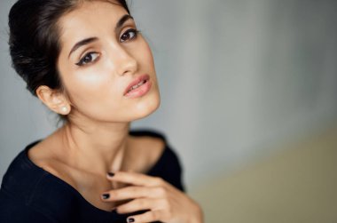 Güzel esmer, siyah bilezik takmış, stüdyo modasında poz veriyor.