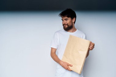 Elinde zanaat paketi olan sakallı bir adam alışveriş yaparken hafif bir geçmişi var.