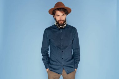 Mavi şapkalı, sakallı, neşeli bir adam.