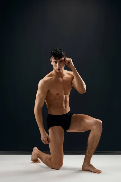 Homem sexy com um corpo bombeado em calcinhas escuras modelo Studio — Fotografia de Stock