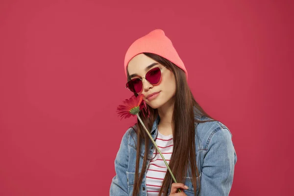 Wspaniały brunetka w różowy kapelusz czerwony kwiat luksusowe pojedyncze tło — Zdjęcie stockowe
